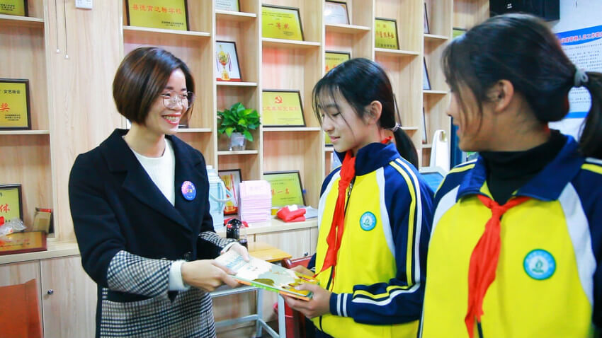 智慧多教育直营校副校长李小琴女士向学生代表们发放作文书籍以及公益捐赠物资
