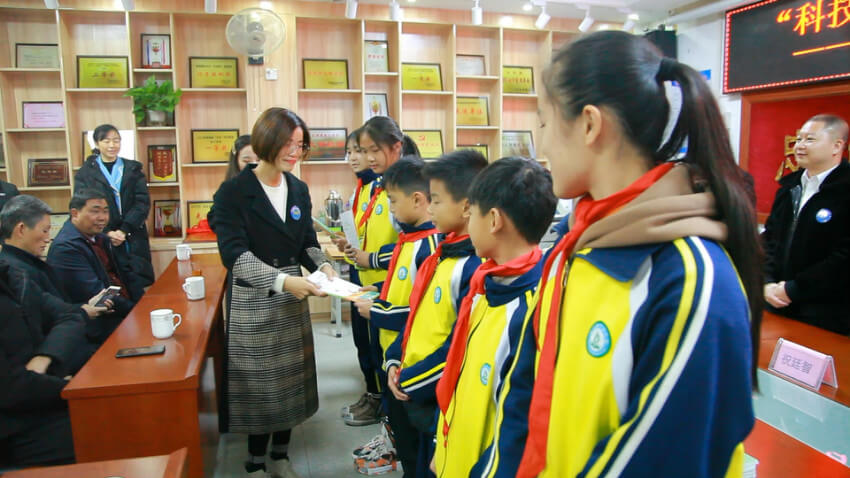 智慧多教育直营校副校长李小琴女士向学生代表们发放作文书籍以及公益捐赠物资
