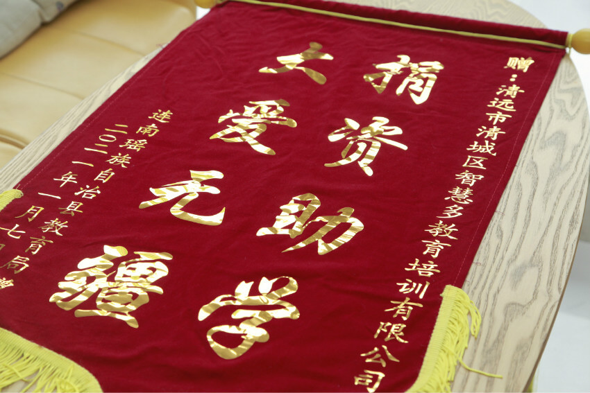 连南瑶族自治县捐赠中心唐主任对智慧多教育授予爱心助学公益锦旗